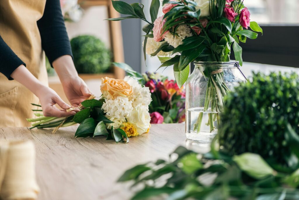 Partial view of florist making bouquet in flower shop